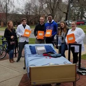 Students pose with a hospital bed. Photo via Erin Hotchkiss.